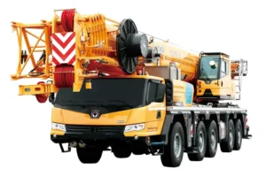 Large yellow XCMG XCA160_S all terrain crane truck with multiple wheels, isolated on white background