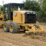 CAT 140 GC Motor Grader with rear ripper/scarifier breaking up a gravel road