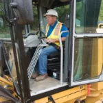 CAT 140 GC Motor Grader cab with lever controls and steering wheel