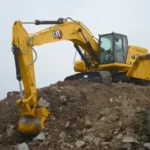 CAT 336 GC Excavator on a rock pile beside a Cat 772G haul truck