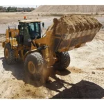 CAT 966 GC Wheel Loader carrying a full bucket of sand on site