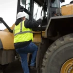 Operator climbing the CAT 980 cab access steps