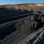 CAT D11 Bulldozer pushing material along parallel slots in an open-pit mine