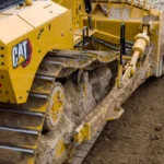CAT D8 Bulldozer push arm, track and SU blade in soil, close-up